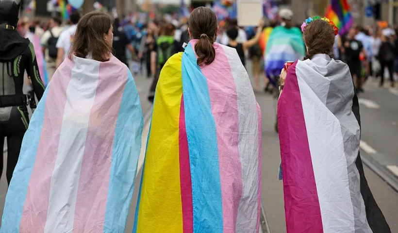 BERLIN, GERMANY - JULY 26: (L-R) Participants draped in the Transgender flag, Pan-sexual flag and asexual flag as the march during the 2025 Christopher Street Day CSD Berlin Pride march on July 26, 2025 in Berlin, Germany. The 47th Berlin CSD is taking place under the motto "Never be silent again!" (Photo by Omer Messinger/Getty Images)
