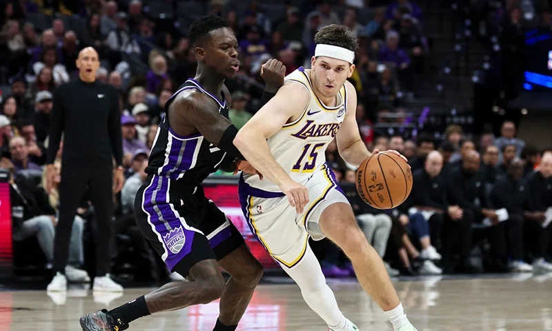 Los Angeles Lakers guard Austin Reaves (15) drives to the basket with Sacramento Kings guard Dennis Schröder, left, defending during the second half of an NBA basketball game Sunday, Oct. 26, 2025, in Sacramento, Calif. (AP Photo/Sara Nevis)