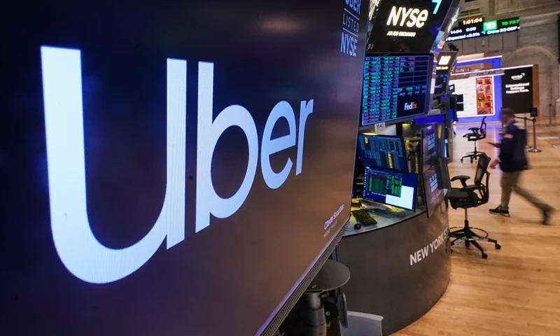 The logo for Uber is displayed above a trading post on the floor of the New York Stock Exchange, Monday, Oct. 20, 2025. (AP Photo/Richard Drew)
