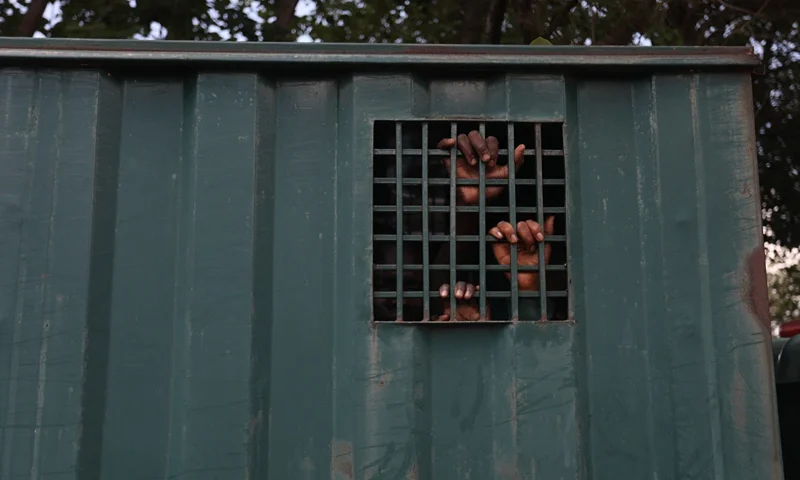 TOPSHOT - The hands of recaptured inmates are seen inside a prison vehicle in Abuja, Nigeria on July 6, 2022, after suspected Boko Haram gunmen attacked the Kuje Medium Prison. Suspected Boko Haram gunmen used explosives to blast their way into a Nigerian prison near the capital, freeing hundreds of inmates in a raid to break out jailed jihadists, the government said on Monday. The brazen attack on the outskirts of Abuja came hours after an ambush on a presidential security convoy in the northwest, in a fresh illustration of Nigeria's security crisis. (Photo by Kola Sulaimon / AFP) (Photo by KOLA SULAIMON/AFP via Getty Images)