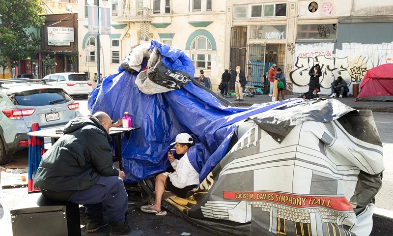 People and their belongings are seen on Jones Street in San Francisco, on November 13, 2023. San Francisco has struggled to clean up the city ahead of hosting world and business leaders. (Photo by Jason Henry / AFP) (Photo by JASON HENRY/AFP via Getty Images)