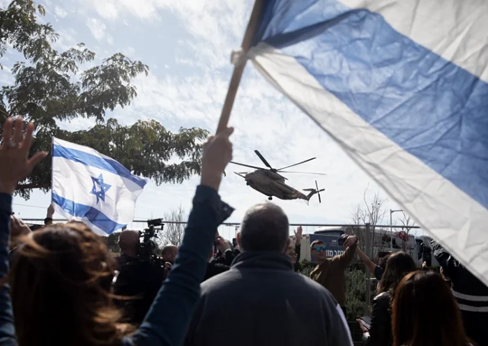 Supporters cheer and hold Israeli flags as an Israeli helicopter carrying freed hostages Sagui Dekel Chen and Sasha Troufanov lands at a hospital after they were released from Hamas captivity on February 15, 2025 in Ramat gan, Israel. Hamas informed the Israeli government on Friday that Sagui Dekel Chen, Alexander Sasha Troufanov and Iair Horn would be released today, as part of a ceasefire deal that seemed in jeopardy earlier in the week. (Photo by Amir Levy/Getty Images)